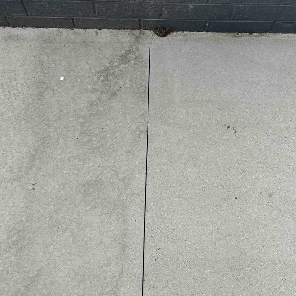 Concrete walkway showing a sharp line between the dirty and freshly cleaned sections